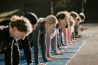 Groepstraining plank op matten in de buitenlucht